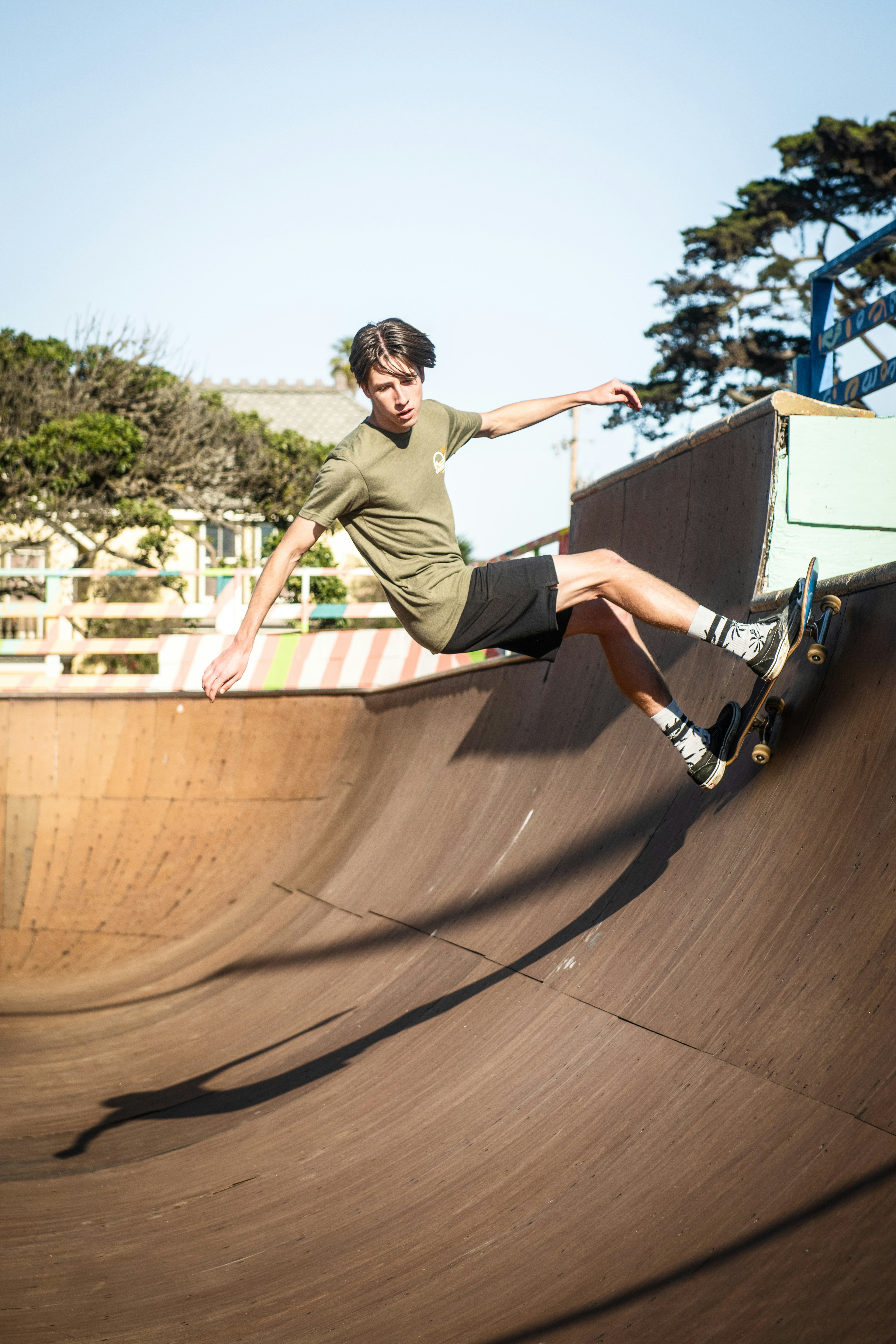 man in green t-shirt and black shorts riding skateboard during daytime